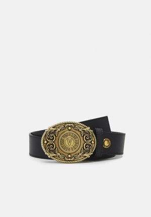 Schwarzer Ledergürtel mit einer verzierten ovalen goldenen Schnalle mit dekorativen Gravuren und dem Wort "VERSACE" rund um ein zentrales "V".