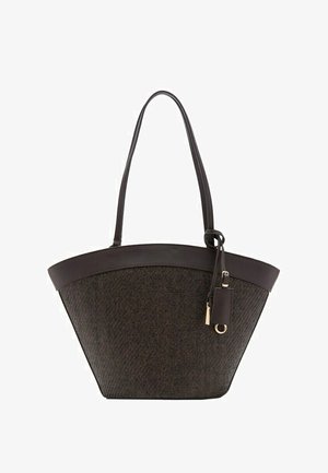 Dark brown woven tote bag with leather trim, long handles, and a small leather tag with gold hardware hanging on one side.