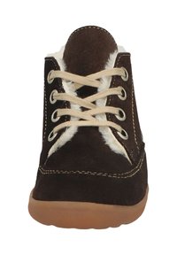 Braune Wildlederstiefel mit cremefarbigem Kunstfellfutter, beigen Schnürsenkeln und einer Gummisohle. Merkmale sind runde Ösen und Kontrastnähte.