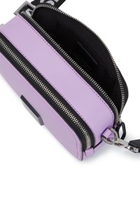 Lilac leather crossbody bag with silver zippers, black accents, and a contrasting interior. Features a detachable strap and textured finish.