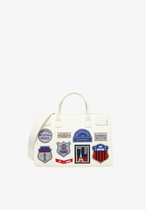 Bolso blanco con asas superiores y parches bordados con temática de París en rojo, azul y negro, con texto y diseños de la Torre Eiffel.