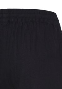 Ceinture élastique noire avec un détail de tissu froncé sur un pantalon ou un short décontracté.