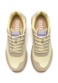 Zapatillas de deporte de color amarillo claro con una parte superior lisa, detalles en beige, puntera redonda y suela exterior de goma texturizada. Incluyen cordones y un logo en la lengüeta.