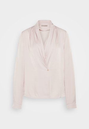 Blouse longue à manches en rose clair avec un col drapé, texture lisse et fermeture à un bouton à l'avant. Tissu doux, coupe décontractée.