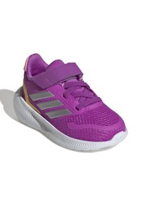 Fioletowy but sportowy z siateczkowej tkaniny, z paskiem na rzep i srebrnymi akcentami. Posiada teksturowaną białą podeszwę oraz różowy uchwyt na pięcie.