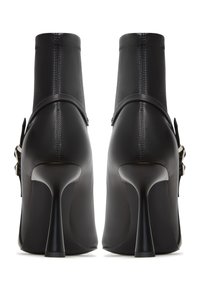 Černé vysoké boty na podpatku s hladkým koženým povrchem, kotníková výška a charakteristický stiletto podpatek. Obsahují tenký řemínek na kotníku.