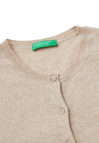 Beiger Cardigan mit Rundhalsausschnitt, drei Knöpfen und geripptem Kragen. Der Stoff ist weich und hat eine dezente Textur. Grünes Markenlabel sichtbar.