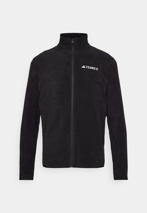 Jachetă din fleece neagră cu guler înalt, fermoar pe toată lungimea și logo-ul alb "TERREX" pe pieptul stâng. Textură moale, fără modele suplimentare.