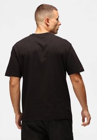 Sort bomulds T-shirt med korte ærmer, rund hals og afslappet pasform. Stoffet har en glat tekstur og minimal detaljering.
