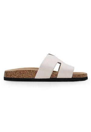 Sandalia deslizante de ante blanco con dos tiras entrelazadas, plantilla de corcho y suela de goma negra texturizada. Diseño de punta abierta, estilo casual.