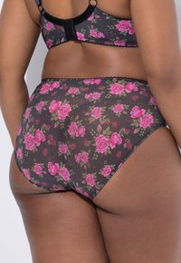 Zwart transparant lingerie set met roze bloemenpatroon. Heeft een kanten rand langs de randen en verstelbare bandjes aan de achterkant.