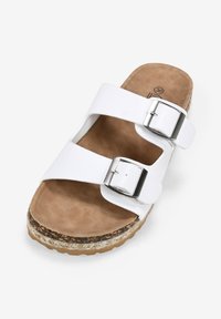 Sandal con due fasce bianche e fibbie argentate, con una soletta marrone testurizzata e una suola con texture naturale per aderenza e comfort.