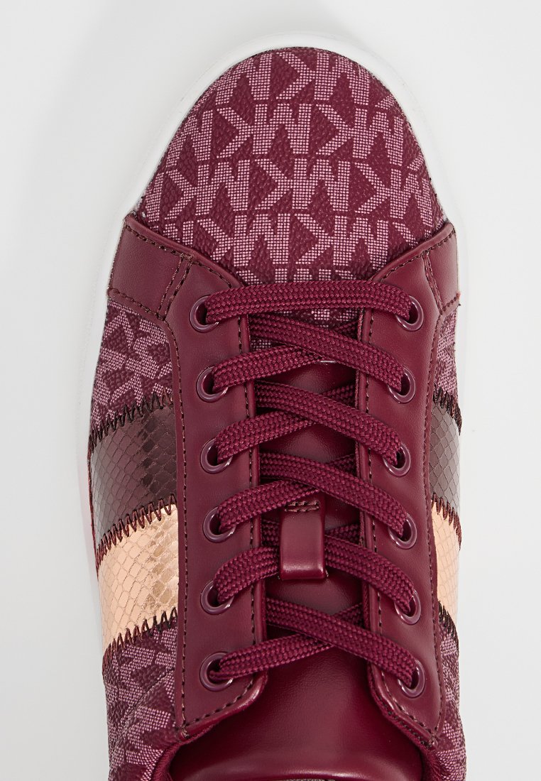 Baskets bordeaux présentant un motif texturé, en simili cuir, avec des lacets tressés et des accents brillants dans des teintes de bronze et de marron foncé.