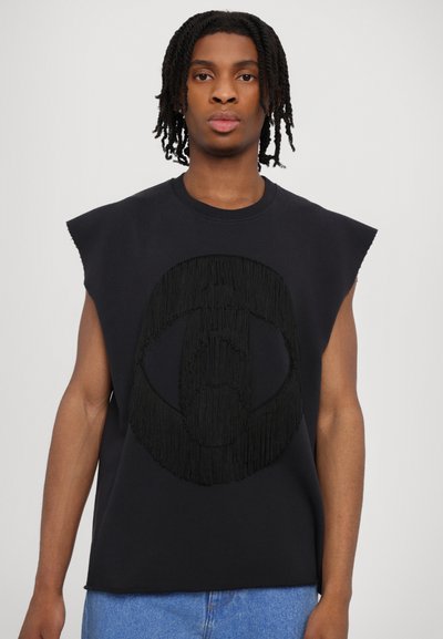 Melns bezpogļu džemperis ar franjām apaļā rakstā, izgatavots no mīkstas auduma. Tam ir apaļa kakla izgriezums un brīva piegriezuma silhouette.