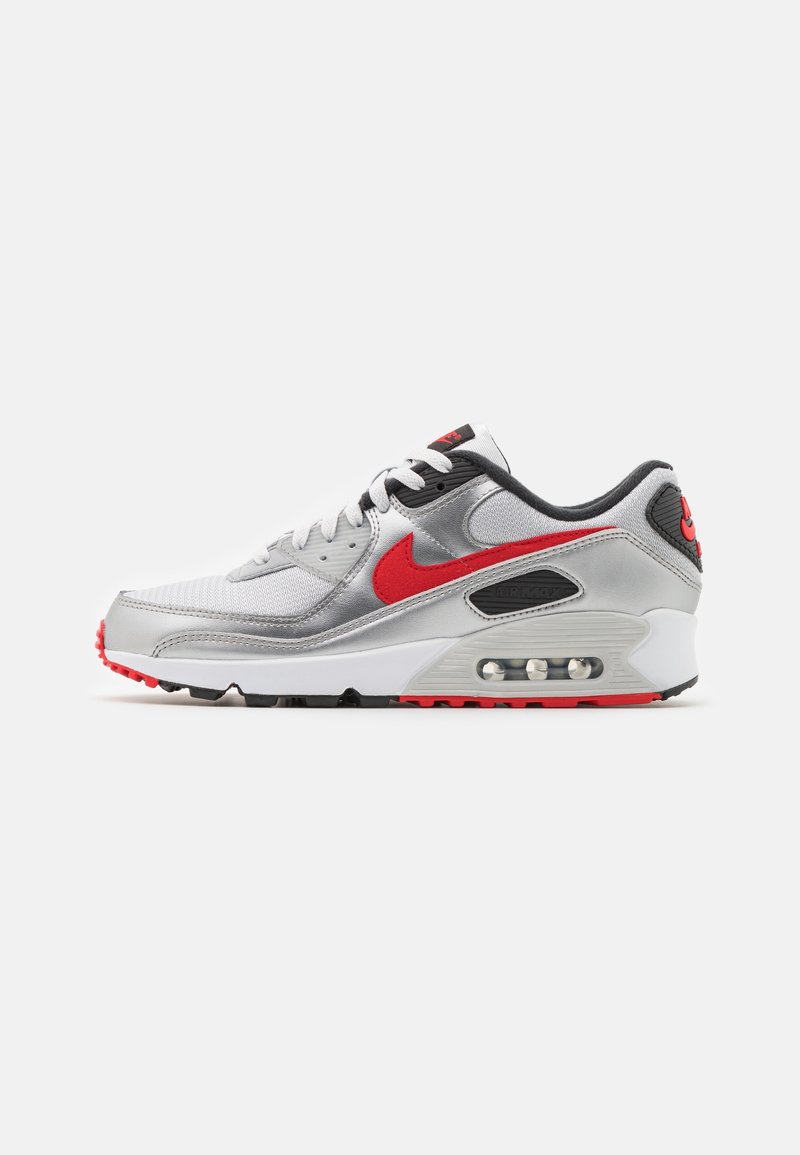 Baskets Nike Air Max argentées et blanches avec un swoosh rouge, semelle à coussin d'air visible, détails noirs et lacets blancs, vues de côté.