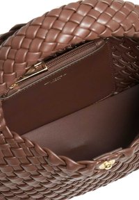 Sac à main en cuir tressé brun avec une anse tressée, doté d'une poche zippée dorée à l'intérieur et d'une texture lisse sur l'ensemble.