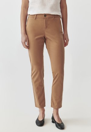 Tan cotton blend trousers with a slim fit, featuring a front button closure, side pockets, and a smooth texture. Paired with black shoes.