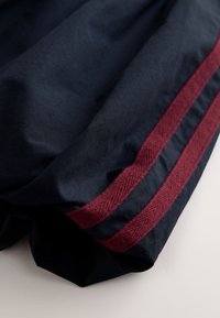 Navy fabric with a smooth texture, featuring a maroon accent stripe along the edge. The material appears lightweight and drapes softly.