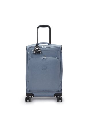 Blue soft-shell suitcase with a retractable handle, four wheels, front zip pocket, and a black character keychain attached.