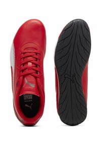 Sneaker rossa Puma con striscia bianca laterale, suola nera testurizzata con logo Puma e lacci, mostrato vista dall'alto e dal basso.