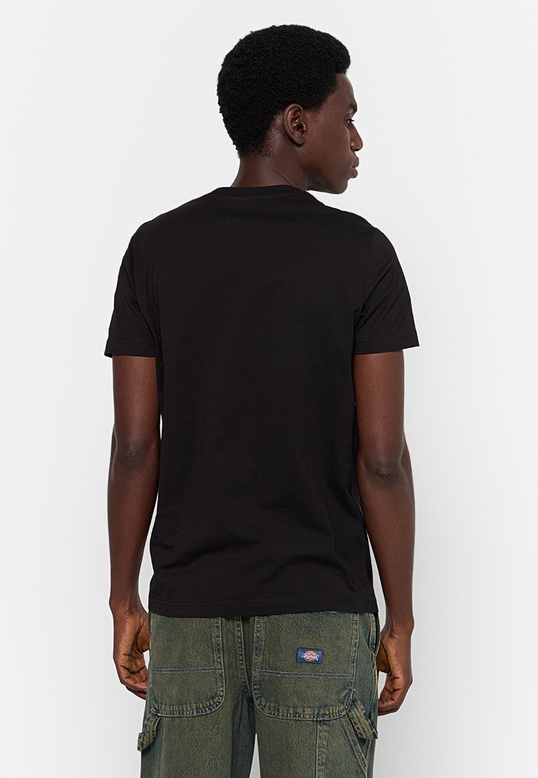 Czarna bawełniana koszulka z klasycznym okrągłym dekoltem i krótkimi rękawami, pokazana z tyłu, zestawiona z oliwkowymi spodniami cargo z kieszeniami.