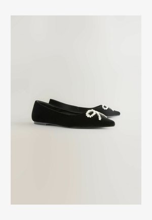 Ballerine in velluto nero con punte appuntite, dotate di un'ornamentazione beaded a forma di nastro frontale. Texture liscia e tacco minimo.