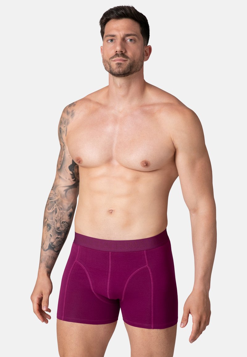 Bordové boxerky so hladkou textúrou a elastickým pásom s jemne embosovaným logom. Fitted dizajn zvýrazňuje tvar tela.