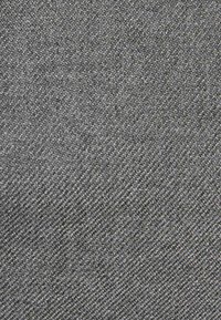 Tessuto grigio scuro con una superficie fine e texturizzata, caratterizzato da una leggera lucentezza e da un motivo di tessitura uniforme.