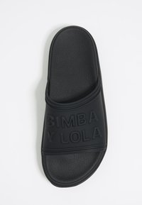 Chancla negra con plantilla texturizada y tira ancha grabada con el logo "BIMBA Y LOLA" sobre fondo blanco.