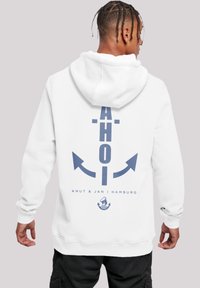 White hooded sweatshirt featuring a navy blue graphic of the word "AHOI" and an anchor design on the back. Soft fabric and relaxed fit.