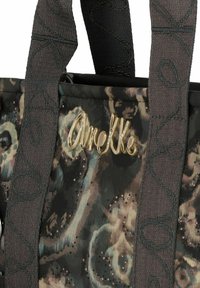Sac fourre-tout noir et multicolore avec un motif floral, matériel orné et sangles texturées arborant un design tourbillonnant. Logo affiché.