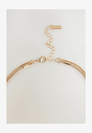 Arany láncnyaklánc, amely dupla textúrájú szemekből áll, és állítható lánccal rendelkezik, lehetővé téve a hosszúság változtatását.