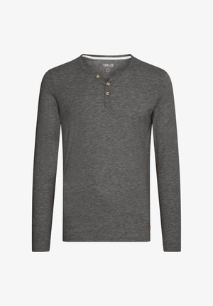 Camisa de manga larga gris con un escote tipo henley, tres botones de madera y una pequeña etiqueta con el logo en la parte inferior izquierda. Tejido suave y texturizado.