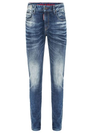 Denim jeans in dark blue with light wash accents. Features five pockets, belt loops, and red label at waistband. Fitted, straight-leg design.