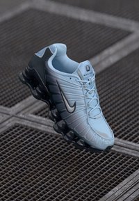 Svijetloplavi Nike tenisice s teksturiranim gornjim dijelom, crnim akcentima i upečatljivim valovitim potplatom, s vezicama i logotipom sa strane.