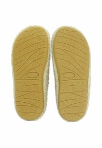 Hellbraune Gummisohle mit strukturiertem Griffmuster, umrandet von einem hellbeigen, flauschigen Material. Keine weiteren Designelemente sichtbar.