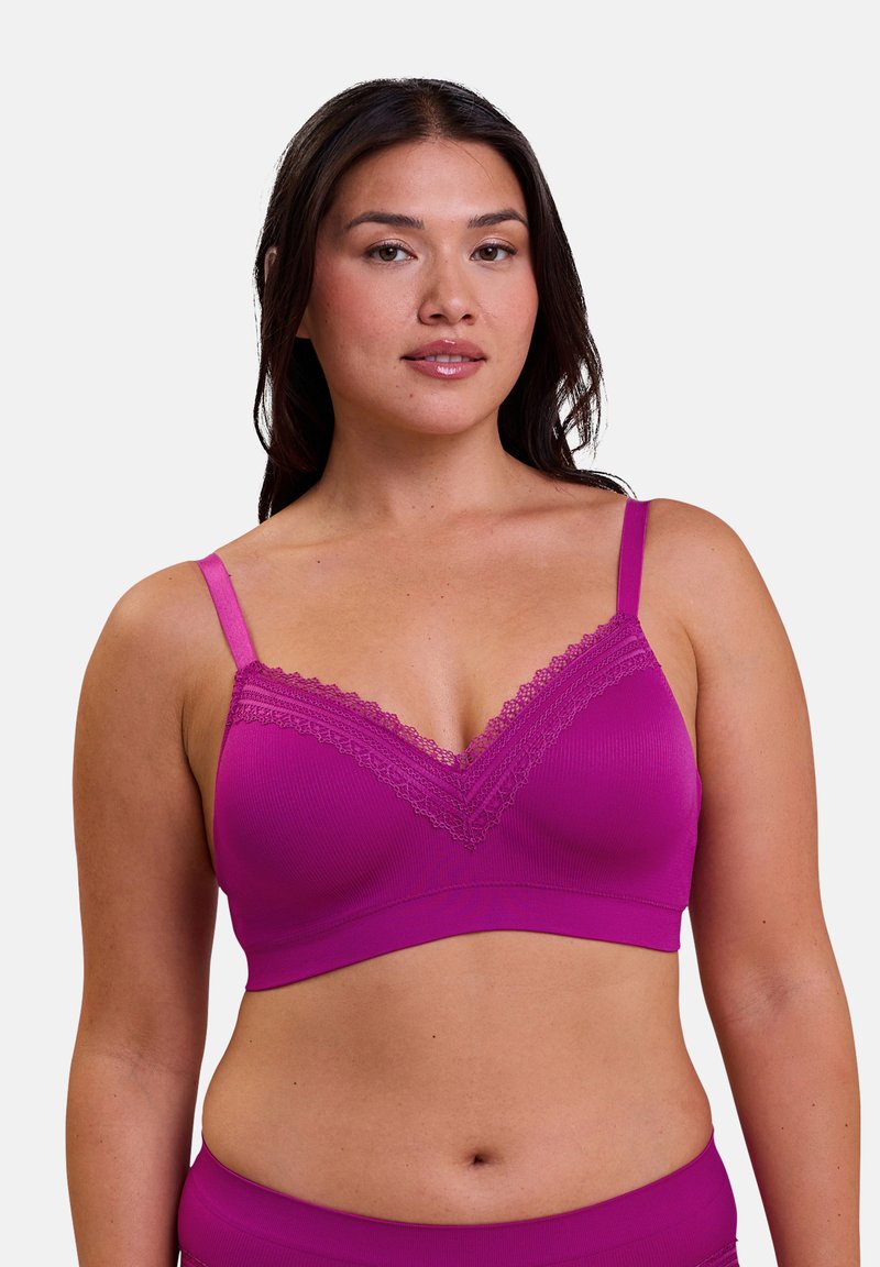 Bralette inalámbrico en fucsia con tejido ribeteado suave, encaje en el escote, tirantes ajustables y un acabado liso para mayor comodidad.