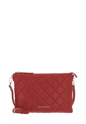 Pochette en cuir rouge avec motif matelassé en forme de losange, fermeture éclair et bandoulière amovible. Dotée de ferrures dorées et du logo de la marque embossé.