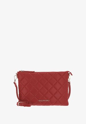 Pochette en cuir rouge avec motif matelassé en forme de losange, fermeture éclair et bandoulière amovible. Dotée de ferrures dorées et du logo de la marque embossé.