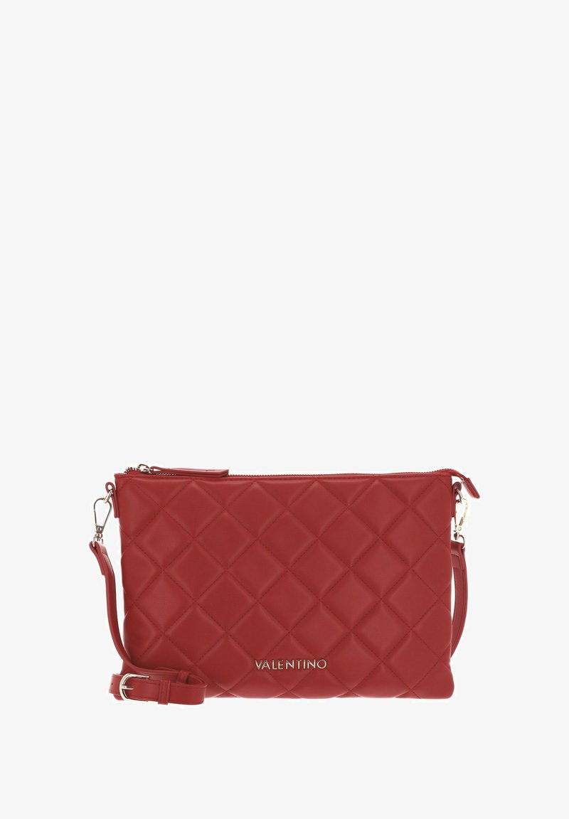 Pochette en cuir rouge avec motif matelassé en forme de losange, fermeture éclair et bandoulière amovible. Dotée de ferrures dorées et du logo de la marque embossé.