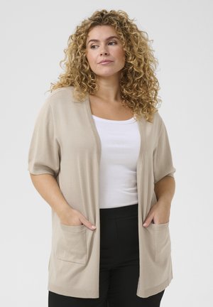 Beige open-front cardigan met korte mouwen, gemaakt van een zachte brei-stof, met twee voorzakken en geribbelde accenten bij de mouwen en de zoom.