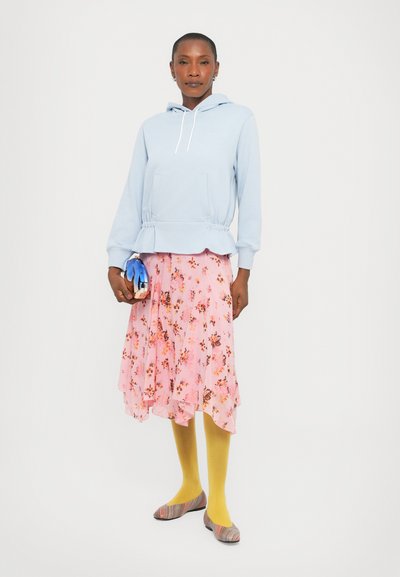 Light blue hoodie with a peplum hem, paired with a pink floral, layered skirt. Yellow tights and multi-striped flats complete the outfit.