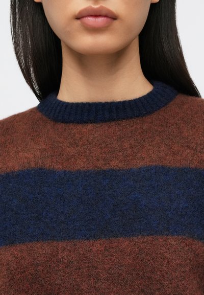 Pulover tricotat cu dungi maro și albastre, cu guler reiat închis la culoare. Textură moale, cu un amestec de lână, prezentând un prim-plan al părții superioare a corpului.