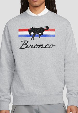 Light gray sweatshirt with a black bucking horse graphic above red, white, and blue stripes and the word "Bronco" in black cursive.