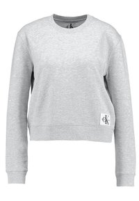 Sudadera gris de mezcla de algodón, con cuello redondo, mangas largas y un diseño recortado, que lleva una etiqueta en la parte inferior izquierda.