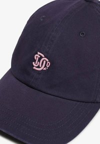Gorra de béisbol navy hecha de algodón, con un logo rosa bordado en la parte frontal. Se puede ver la visera curvada y los ojales para ventilación.