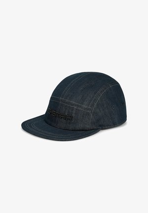Casquette en denim bleu foncé avec une visière plate et un logo G-Star noir brodé au centre avant, présentée sur fond blanc.