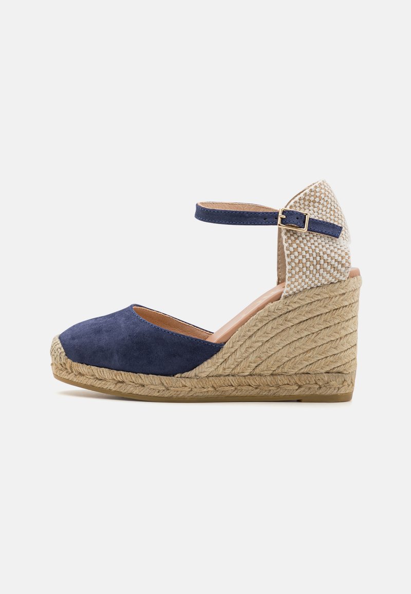 Chaussure en suede marine à talon compensé avec une bride à la cheville, dotée d'un talon tissé texturé et d'un détail en jute, structurée avec un bout arrondi.