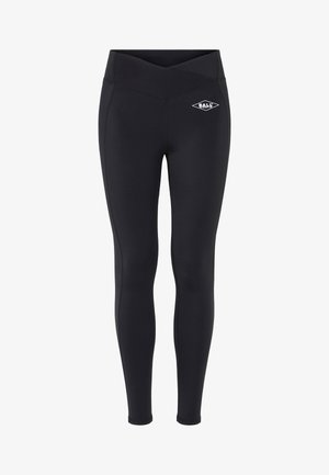 Črne športne legice iz elastičnega materiala, s križnim pasom in majhnim belim logotipom na stegnu.