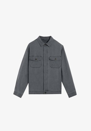 Chaqueta de mezclilla gris con cuello, dos bolsillos en el pecho, cierre de botones y mangas largas. Textura suave, diseño minimalista y corte recto.